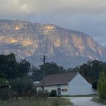 Looking towards the Old Bakery building on the Market Place, Glen Davis town, Cliffs of Capertee Valley behind lit by the rising sun.