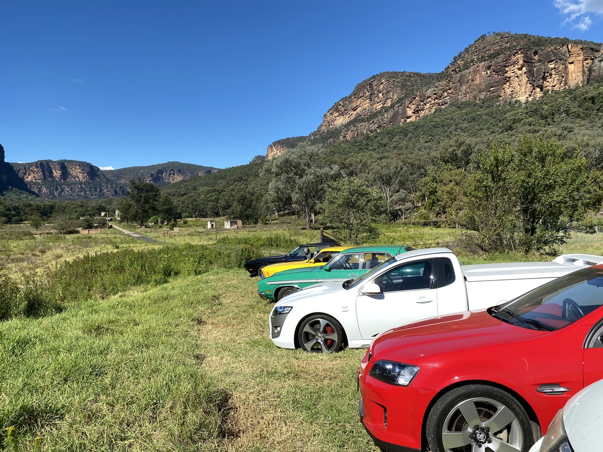 Glen Davis Tour 20240413 Nowra classic cars in foreground and shale works ruins in background.